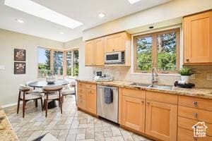 3525 E Ceres Dr S, Millcreek, UT 84124 - kitchen with stainless steel appliances, a sink, decorative backsplash, light brown cabinetry, and light stone finish flooring