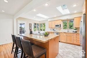 3525 E Ceres Dr S, Millcreek, UT 84124 - kitchen with a skylight, a breakfast bar area, a kitchen island, healthy amount of natural light, and recessed lighting