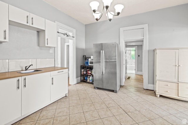 299 N 100 E, Salina, UT 84654 - kitchen with freestanding refrigerator, a sink, a chandelier, and light tile patterned floors