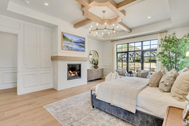 423 S 150 E, Mapleton, UT 84664 - bedroom with a decorative wall, a chandelier, light wood-style flooring, a glass covered fireplace, and coffered ceiling