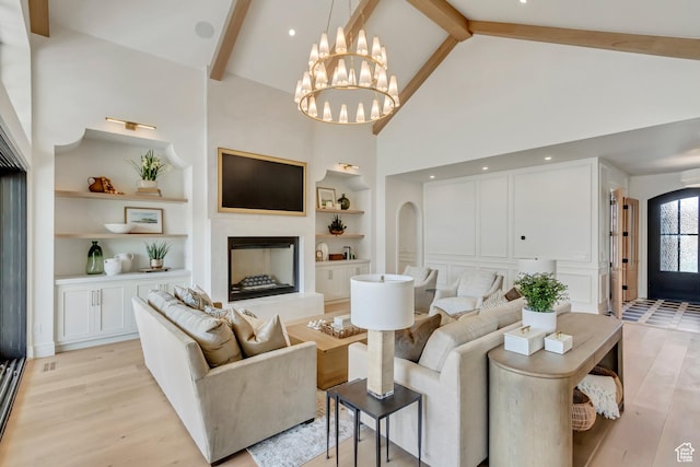 423 S 150 E, Mapleton, UT 84664 - living area featuring built in shelves, light wood finished floors, high vaulted ceiling, beam ceiling, and a chandelier