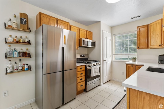 3709 S Angelico Ct Unit D, West Valley City, UT 84119 - kitchen featuring appliances with stainless steel finishes, light countertops, a sink, baseboards, and light tile patterned flooring