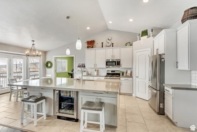 5617 W High Spirit Ct, Herriman, UT 84096 - kitchen featuring appliances with stainless steel finishes, beverage cooler, a breakfast bar area, lofted ceiling, and white cabinets