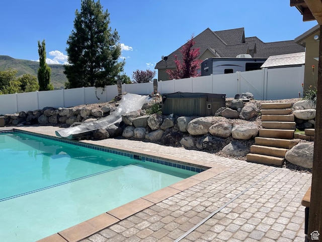 5617 W High Spirit Ct, Herriman, UT 84096 - view of swimming pool with a hot tub, a fenced backyard, a patio area, and a mountain view