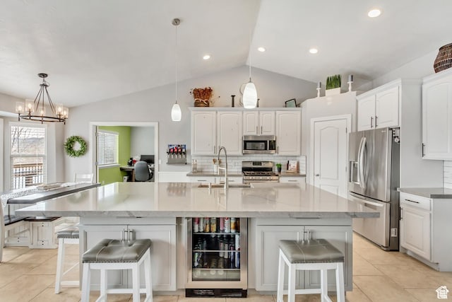 5617 W High Spirit Ct, Herriman, UT 84096 - kitchen with appliances with stainless steel finishes, vaulted ceiling, tasteful backsplash, white cabinetry, and a kitchen bar