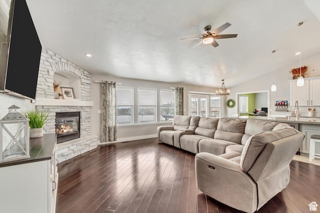 5617 W High Spirit Ct, Herriman, UT 84096 - living room featuring lofted ceiling, a ceiling fan, a fireplace, dark wood-style flooring, and a chandelier