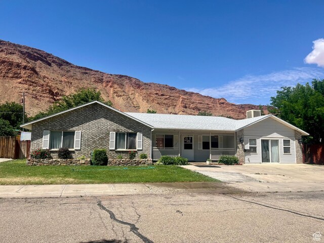 766 Huntridge Dr, Moab, UT 84532 - ranch-style house featuring a mountain view, brick siding, and covered porch