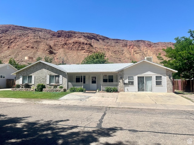 766 Huntridge Dr, Moab, UT 84532 - single story home with brick siding, a porch, and a mountain view