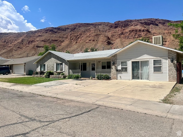 766 Huntridge Dr, Moab, UT 84532 - ranch-style house featuring a porch, brick siding, and a mountain view