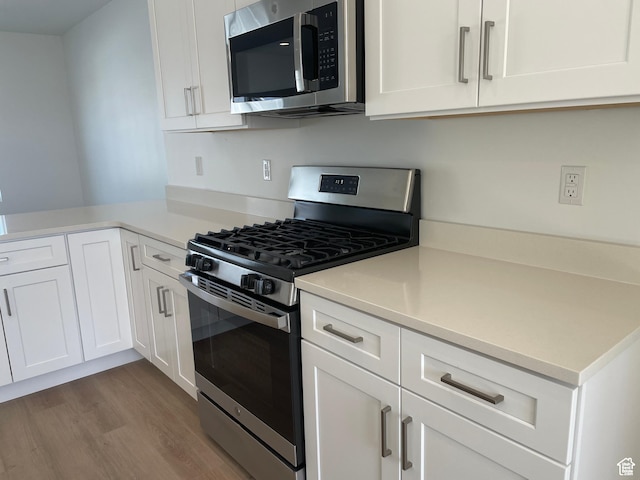 1650 N Main St N Unit 126, Layton, UT 84041 - kitchen featuring appliances with stainless steel finishes, white cabinetry, wood finished floors, and light countertops