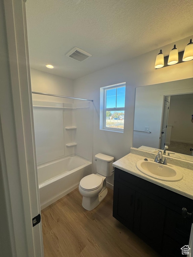 1650 N Main St N Unit 126, Layton, UT 84041 - bathroom with wood finished floors, toilet, vanity, a textured ceiling, and tub / shower combination