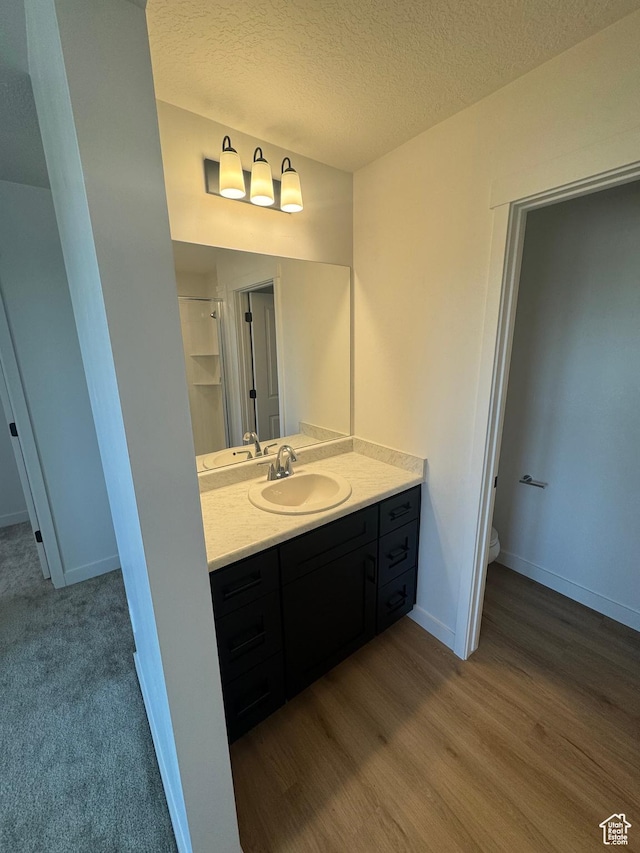 1650 N Main St N Unit 126, Layton, UT 84041 - bathroom with vanity, toilet, a textured ceiling, wood finished floors, and baseboards