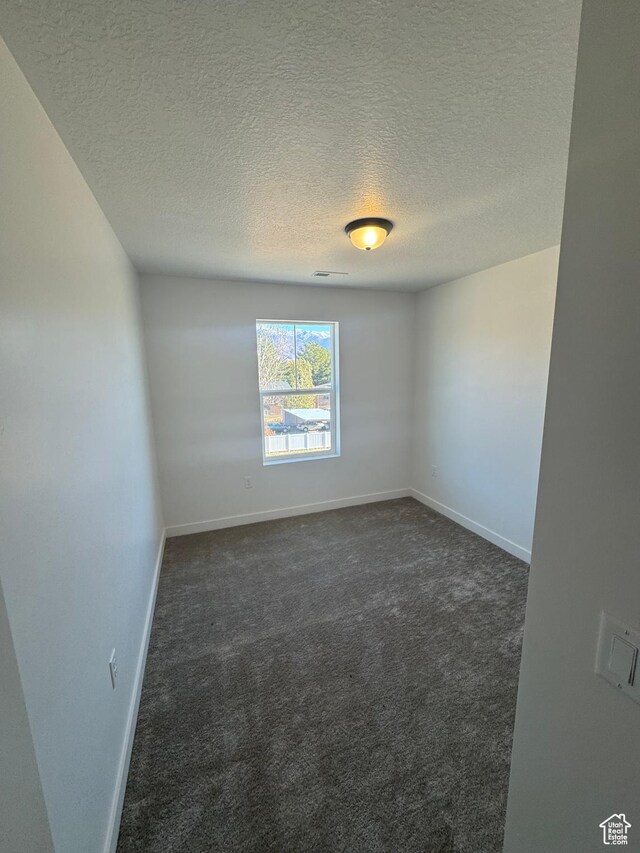 1650 N Main St N Unit 126, Layton, UT 84041 - spare room featuring dark carpet, a textured ceiling, and baseboards