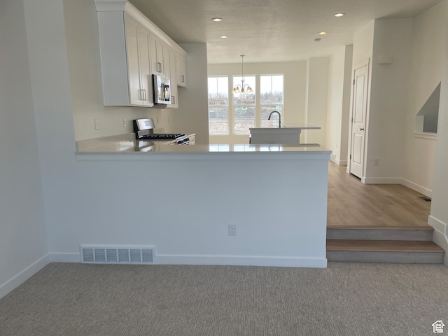 1650 N Main St N Unit 126, Layton, UT 84041 - kitchen featuring stove, stainless steel microwave, a chandelier, light countertops, and recessed lighting