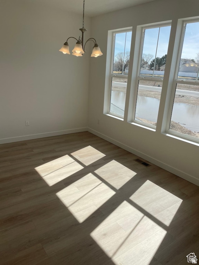 1650 N Main St N Unit 126, Layton, UT 84041 - empty room featuring a chandelier, baseboards, and wood finished floors