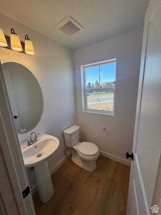 1650 N Main St N Unit 126, Layton, UT 84041 - half bathroom featuring wood finished floors, toilet, a textured ceiling, and baseboards