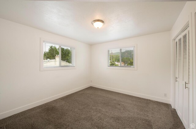 1779 E Ramona Ave S, Salt Lake City, UT 84108 - unfurnished bedroom featuring multiple windows, dark carpet, and a closet