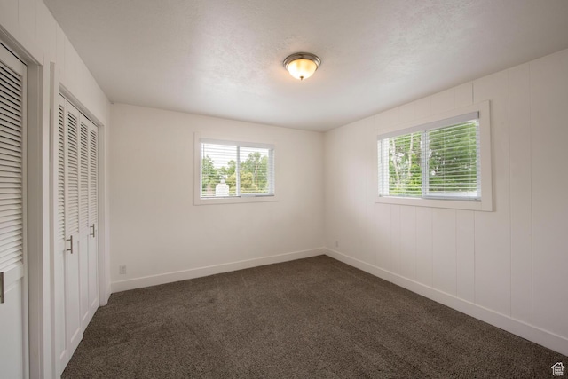 1779 E Ramona Ave S, Salt Lake City, UT 84108 - unfurnished bedroom with multiple windows, dark colored carpet, and baseboards