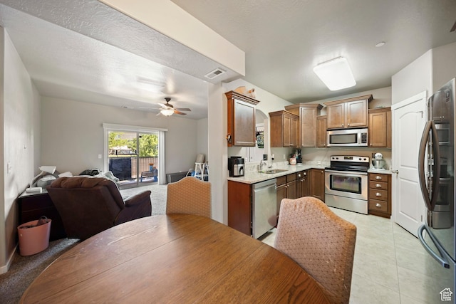 107 E Jordan Blvd Unit 506, Saratoga Springs, UT 84045 - kitchen with stainless steel appliances, open floor plan, a sink, light countertops, and brown cabinets