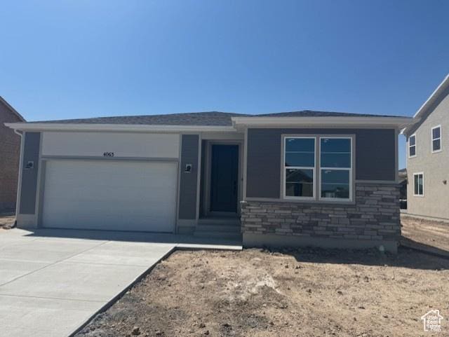 4063 W 2025 S Unit 39, Taylor, UT 84401 - view of front of property featuring a garage, stone siding, and driveway