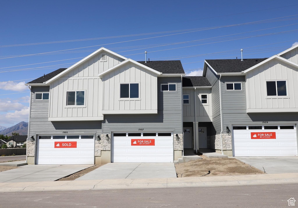 1907 E 1420 N, Spanish Fork, UT 84660 - view of front facade with board and batten siding, an attached garage, a mountain view, and driveway