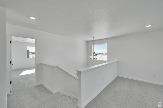 1972 E Burger St Unit 1236, Lake Point, UT 84074 - hallway featuring an upstairs landing, light carpet, a chandelier, baseboards, and recessed lighting