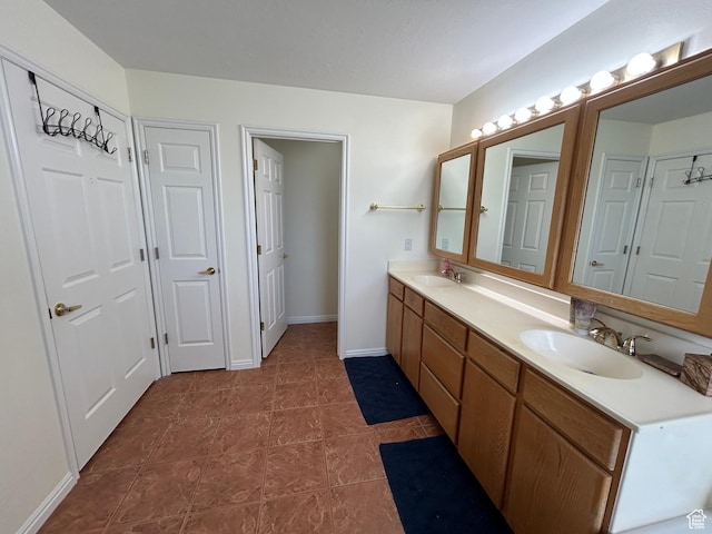 4306 Elk Ln, Erda, UT 84074 - bathroom featuring double vanity, tile patterned flooring, and baseboards
