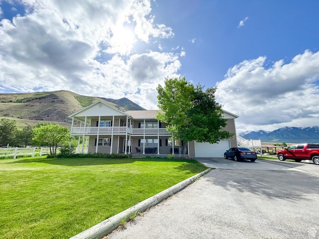 4306 Elk Ln, Erda, UT 84074 - view of front of home featuring a balcony, a mountain view, driveway, and covered porch