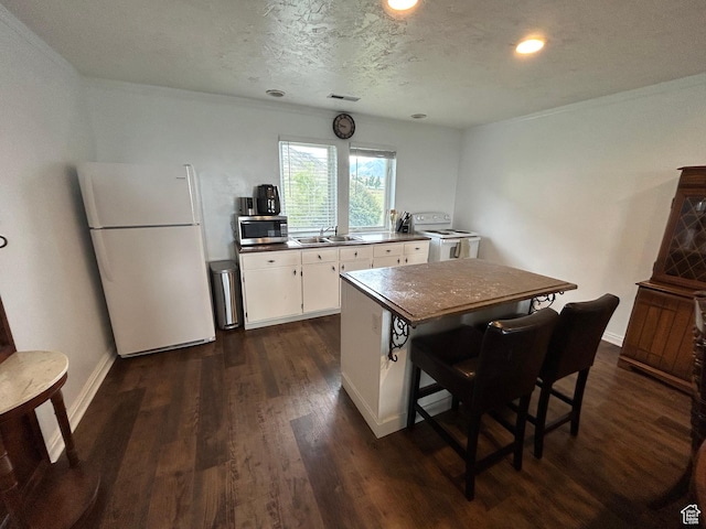 4306 Elk Ln, Erda, UT 84074 - kitchen with white appliances, a sink, dark wood finished floors, white cabinetry, and washer / clothes dryer