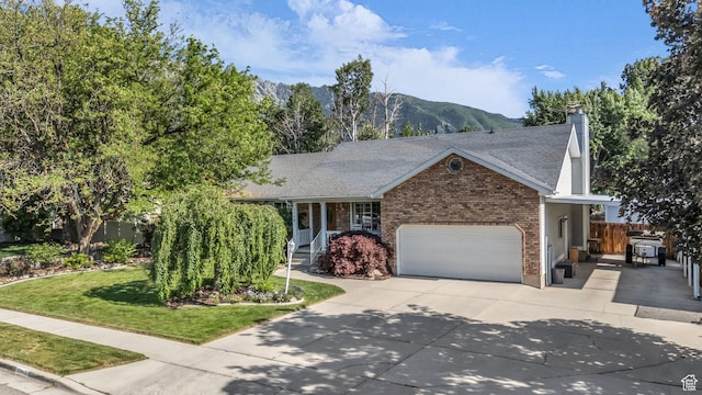 2268 E 10140 S, Sandy, UT 84092 - view of front facade with an attached garage, brick siding, driveway, a mountain view, and a chimney