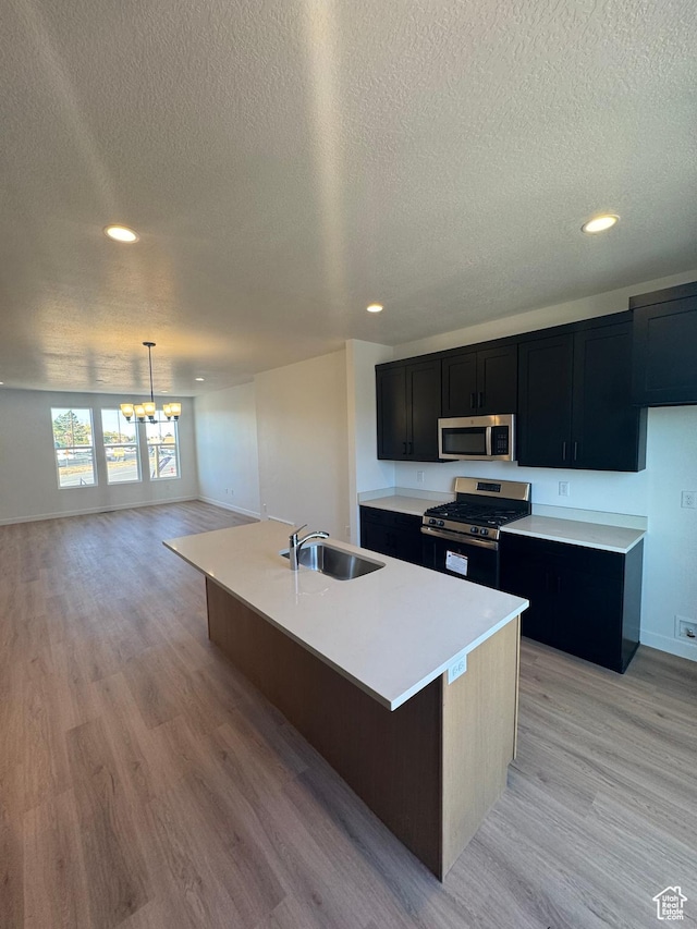 1650 N Main St N Unit 125, Layton, UT 84041 - kitchen with stainless steel appliances, dark cabinets, a textured ceiling, a chandelier, and recessed lighting