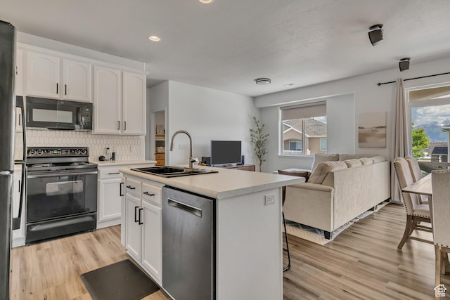 7284 S Brittany Park Ave, West Jordan, UT 84084 - kitchen featuring black appliances, a sink, open floor plan, plenty of natural light, and recessed lighting