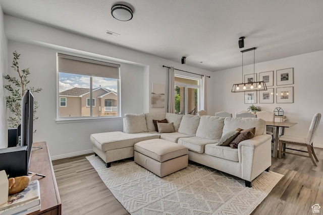 7284 S Brittany Park Ave, West Jordan, UT 84084 - living room with wood finished floors, a chandelier, and healthy amount of natural light