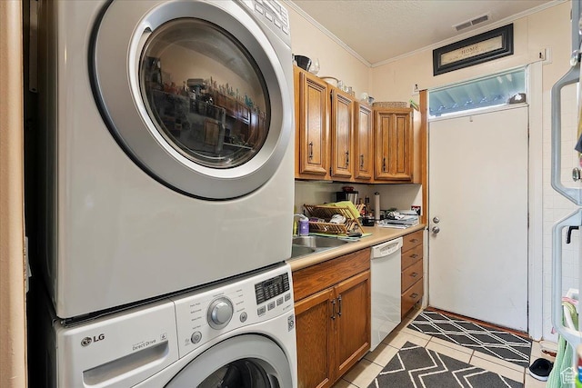 1183 S Hoytsville Rd Unit A, Hoytsville, UT 84017 - laundry room featuring stacked washer / dryer, crown molding, light tile patterned flooring, and cabinet space