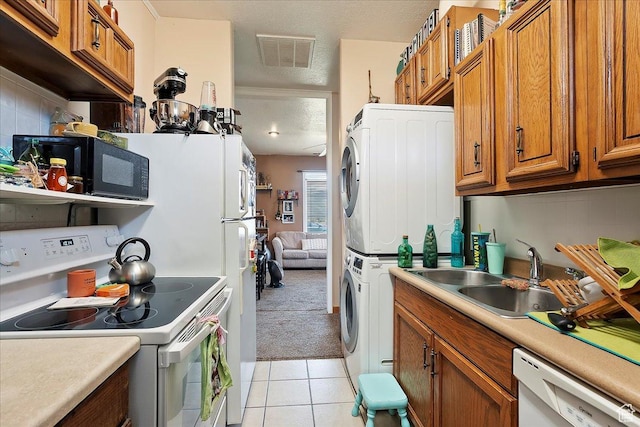 1183 S Hoytsville Rd Unit A, Hoytsville, UT 84017 - kitchen featuring white appliances, stacked washer and clothes dryer, brown cabinetry, a sink, and light countertops