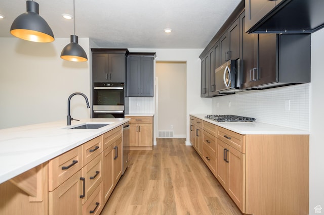 166 N Husker Ln, Saratoga Springs, UT 84045 - kitchen featuring stainless steel appliances, a sink, light countertops, light wood-style floors, and tasteful backsplash