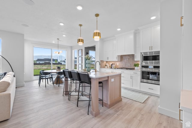 3164 N 3500 W, Plain City, UT 84404 - kitchen featuring stainless steel appliances, light countertops, baseboards, backsplash, and light wood finished floors