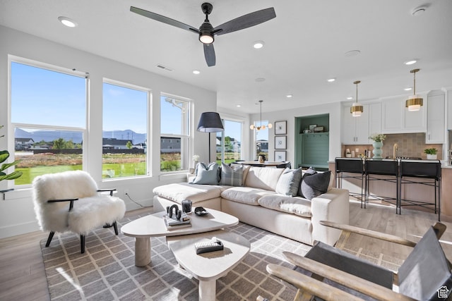 3164 N 3500 W, Plain City, UT 84404 - living room with light wood finished floors, recessed lighting, a ceiling fan, a mountain view, and baseboards