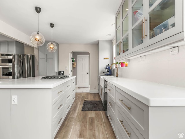 167 N 750 E, Orem, UT 84097 - kitchen with appliances with stainless steel finishes, arched walkways, light wood-type flooring, light countertops, and a center island