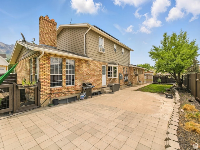 167 N 750 E, Orem, UT 84097 - rear view of property featuring a chimney, a patio area, brick siding, a fenced backyard, and cooling unit