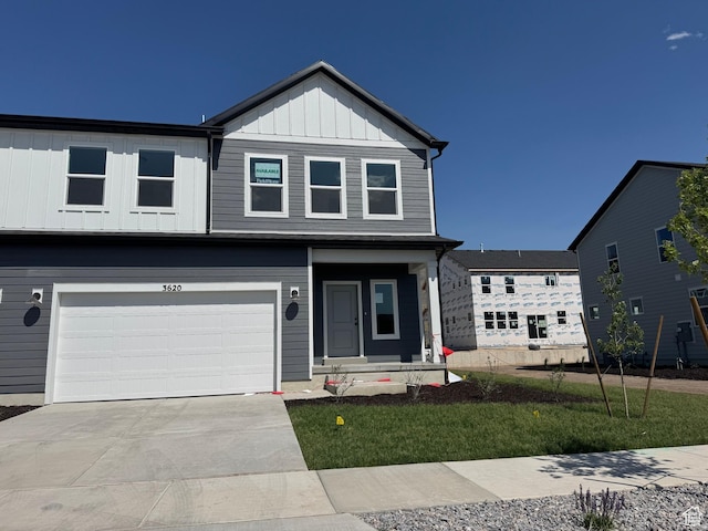 3620 N Stallion St Unit 349, Eagle Mountain, UT 84005 - view of front of house featuring an attached garage, driveway, board and batten siding, and a front lawn