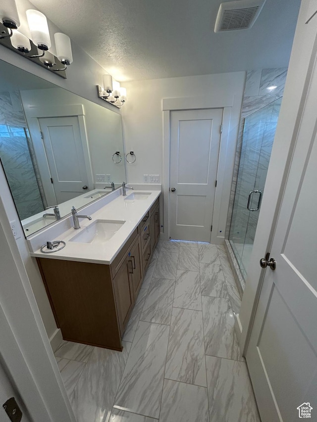 572 N 600 W, Smithfield, UT 84335 - bathroom with marble look tiles, double vanity, a shower stall, and a textured ceiling