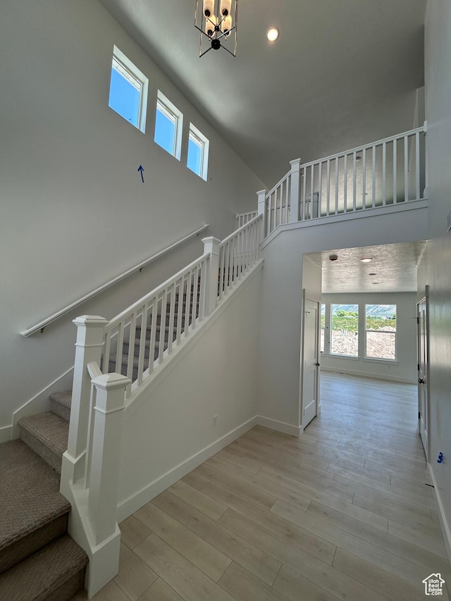 572 N 600 W, Smithfield, UT 84335 - stairway featuring healthy amount of natural light, wood finished floors, a towering ceiling, baseboards, and a chandelier