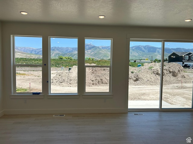572 N 600 W, Smithfield, UT 84335 - doorway to outside with a mountain view, wood finished floors, baseboards, a textured ceiling, and recessed lighting