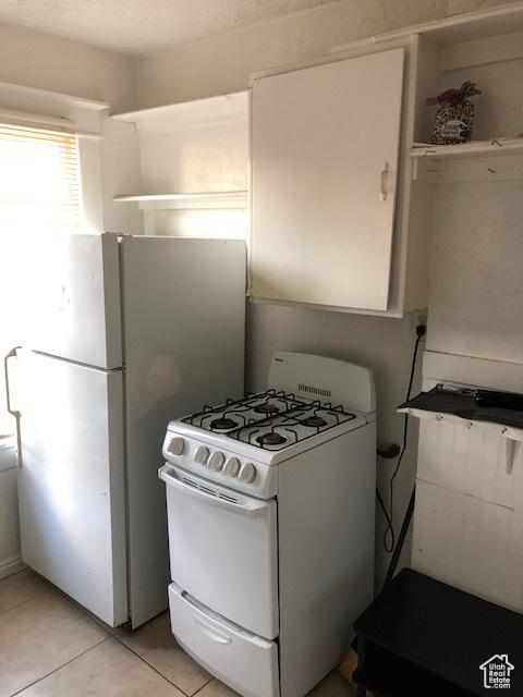 827 E 26th St, Ogden, UT 84401 - kitchen featuring white appliances, light tile patterned flooring, open shelves, and white cabinets
