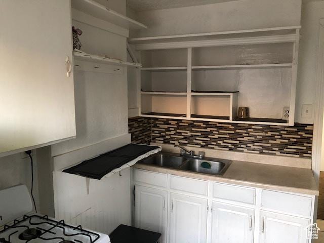 827 E 26th St, Ogden, UT 84401 - kitchen with open shelves, a sink, backsplash, and white cabinets