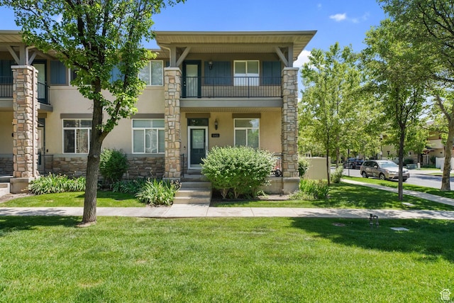 11411 S Oakmond Rd, South Jordan, UT 84009 - townhome / multi-family property featuring stone siding, stucco siding, a front yard, and a balcony