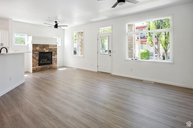 11411 S Oakmond Rd, South Jordan, UT 84009 - unfurnished living room with a ceiling fan, a fireplace, and light wood-type flooring