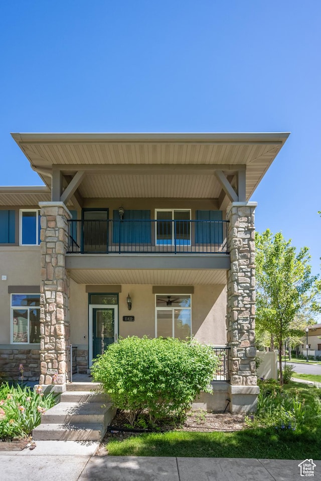 11411 S Oakmond Rd, South Jordan, UT 84009 - view of front of house featuring a balcony, stucco siding, stone siding, and a porch
