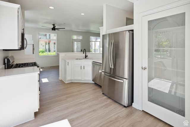 11411 S Oakmond Rd, South Jordan, UT 84009 - kitchen with stainless steel appliances, a sink, a peninsula, a ceiling fan, and light wood-type flooring